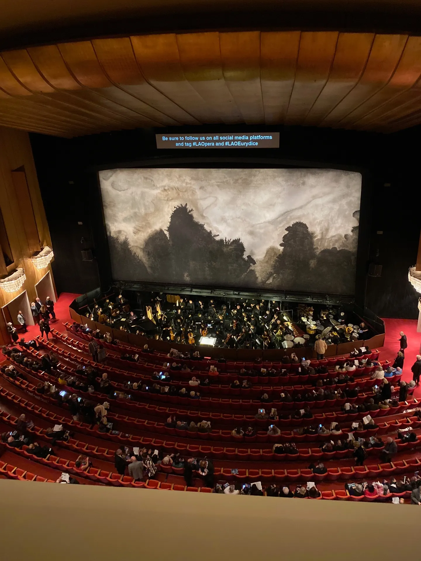 LA Opera house with audience filing in and a black-and-white mountain scrim onstage