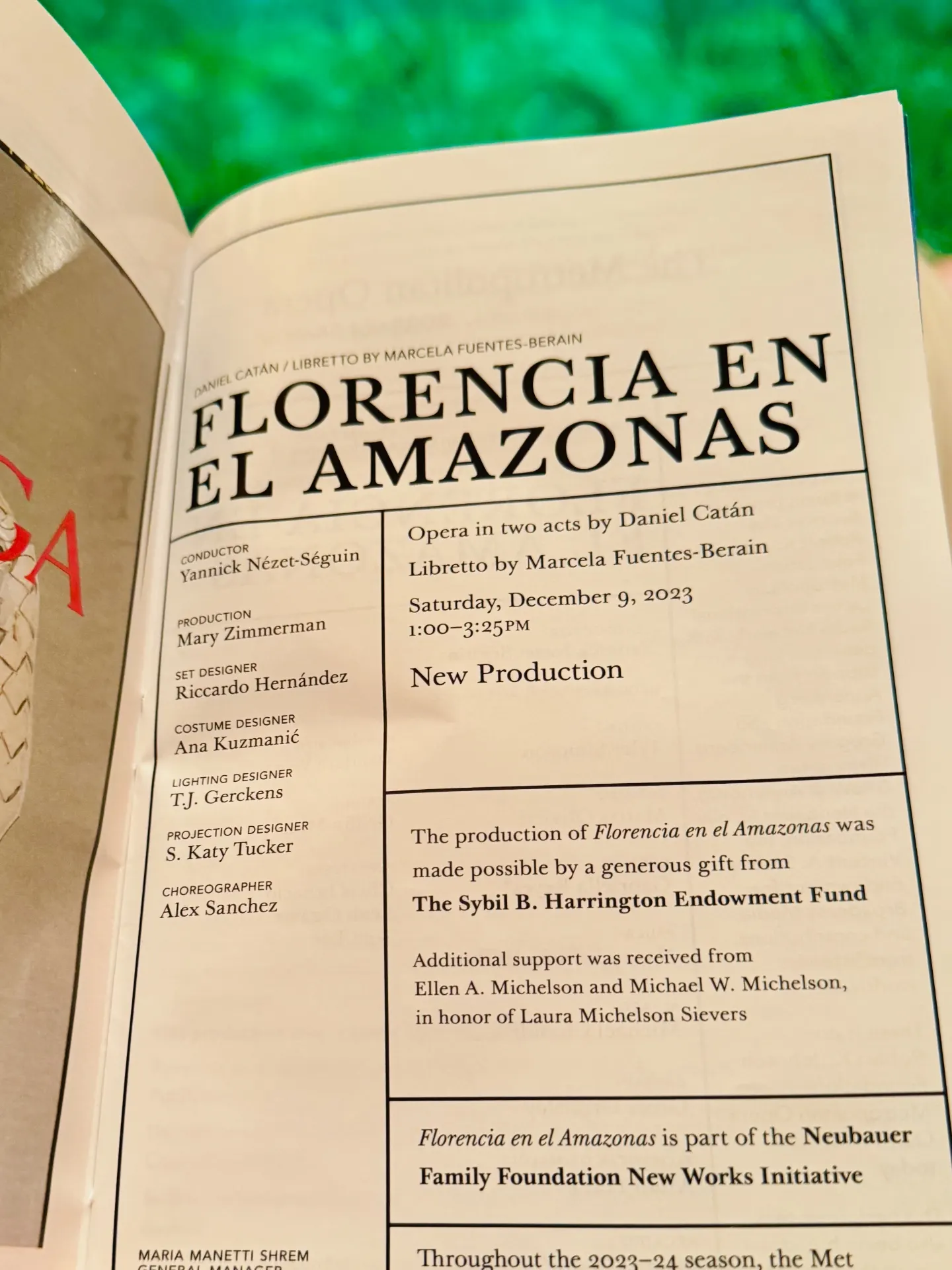 Open Met Playbill page for Florencia en el Amazonas with the credits panel — Yannick Nézet-Séguin conducting, Mary Zimmerman directing — held over the green show curtain