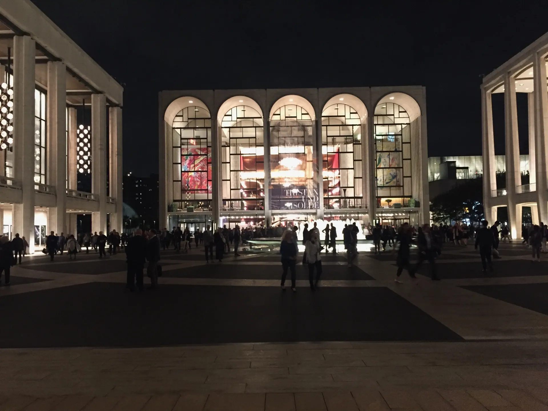 Lincoln Center plaza at night with crowds outside the Metropolitan Opera