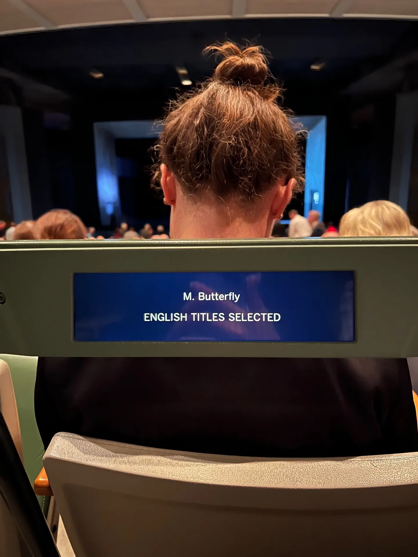 Met Titles seat-back screen displaying 'M. Butterfly — English Titles Selected' before the performance