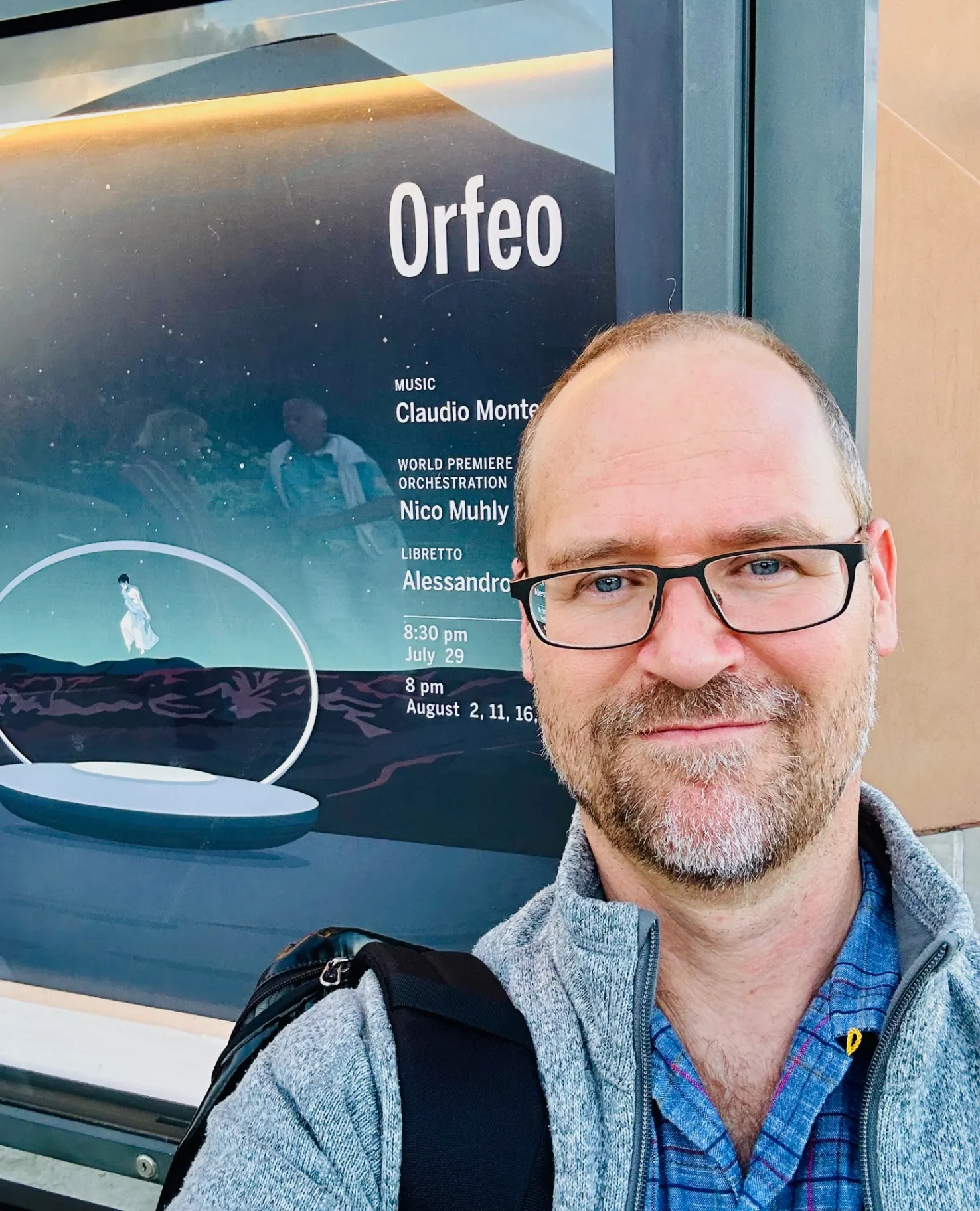 Selfie in front of a Santa Fe Opera poster for Orfeo with production text and dates visible