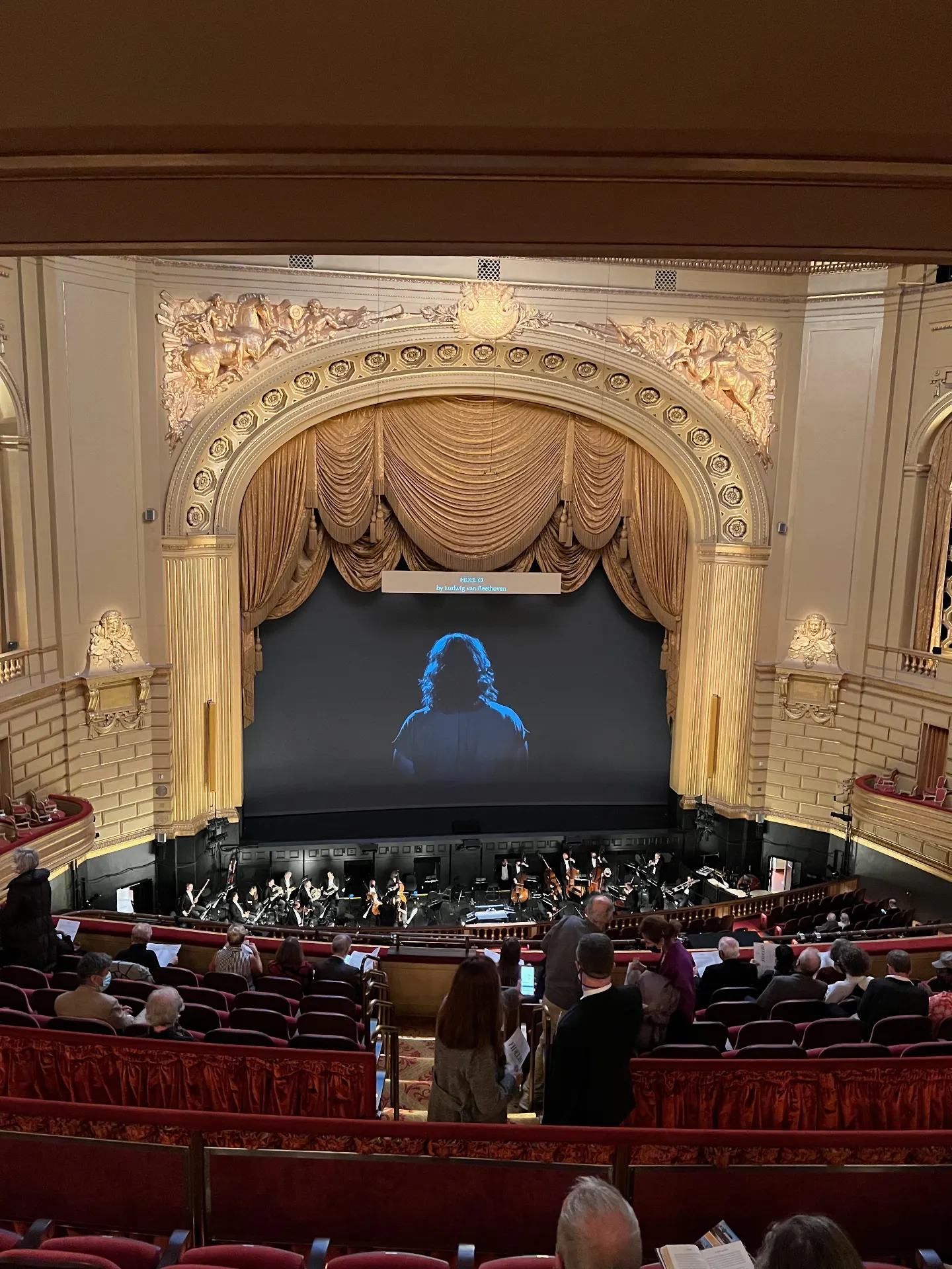 War Memorial Opera House proscenium with a projected film of a singer's back, performing Fidelio during the pandemic